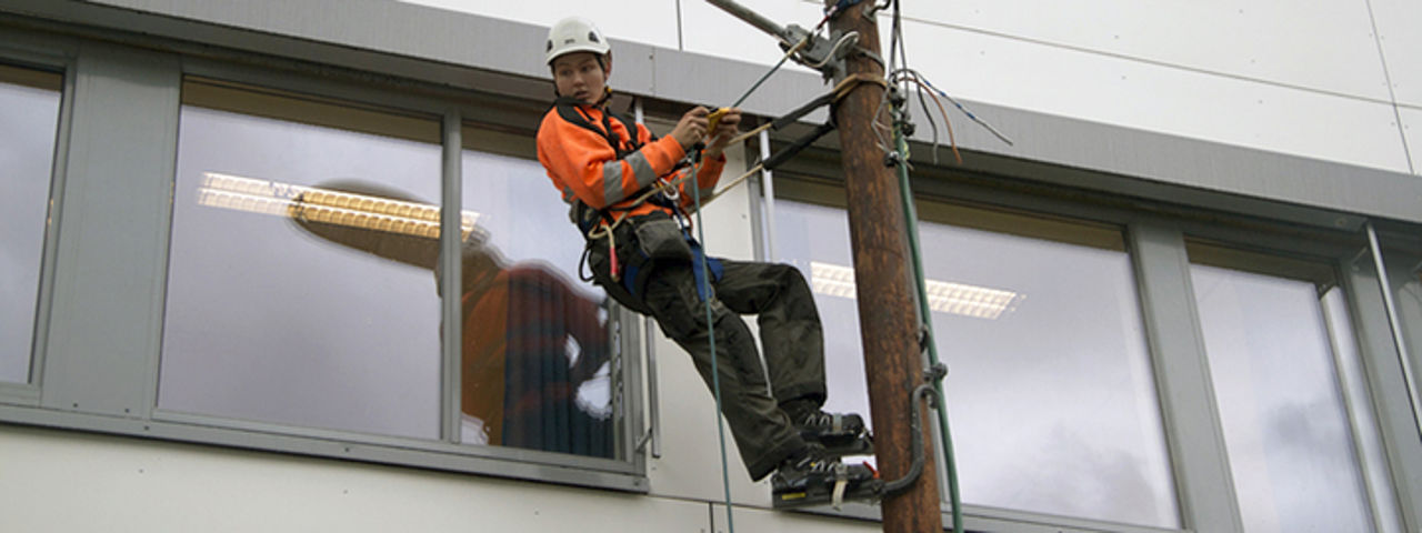 Elev på elektro som utfører arbeid i ein lysstolpe